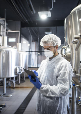 technologist-white-protective-clothes-checking-production-his-tablet©freepik